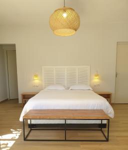 um quarto com uma cama grande e uma luz pendente em Relais De Mantadia em Andasibe