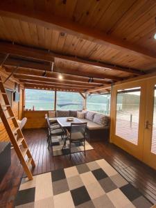 a living room with a table and chairs and a couch at Viridian Three Boathouse Micah, PERUCAC LAKE in Perućac
