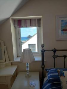 a bedroom with a bed and a window at Karrek View - Trebarwith Strand (Sleeps 8-10) in Treknow
