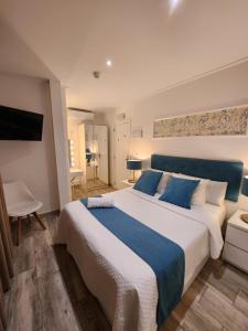 a bedroom with a large bed with a blue headboard at DON LEONE Hotel in Alginet