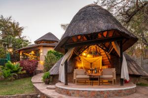 a gazebo with a table and chairs in it at Hornbill Lodge in Kariba