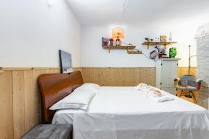 ein Schlafzimmer mit einem Bett mit weißer Bettwäsche und einem Stuhl in der Unterkunft San Nicola Apartments by Rentbeat in Bari