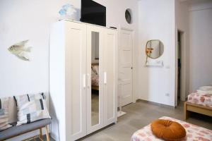 a white cabinet with a television on top of it at Granello di Sabbia - Chianalea di Scilla in Scilla