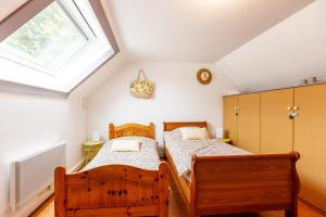 two beds in a room with a window at Gîte du Château in Naours