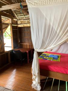 1 dormitorio con cama con dosel y mesa en Gibran guest house, en Kri