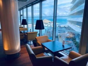 um quarto com uma mesa e cadeiras e vista para o oceano em Studio front de mer Biarritz - Spa & Thalasso em Biarritz