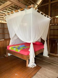 a bed with a canopy in a room at Gibran guest house in Kri
