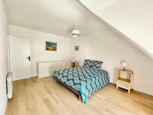 1 dormitorio blanco con 1 cama y suelo de madera en LE GRAND PALAIS - Centre Ville - Palais de justice en Quimper