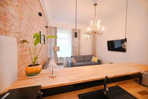 a living room with a wooden table and a brick wall at Victus Apartamenty, Apartament Antique 1 in Sopot