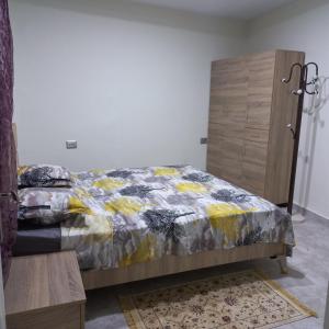 a bedroom with a bed and a wooden cabinet at residence djerba 2 in Houmt Souk