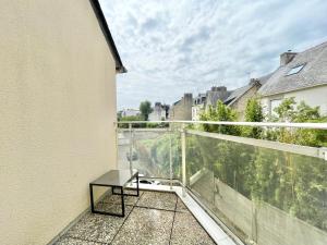 uma varanda com uma mesa e uma vista em LE GRAND PALAIS - Centre Ville - Palais de justice em Quimper