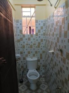 baño con aseo y ventana en Devine 1 bedroom on Moi Southlake road en Naivasha