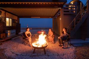 a group of people sitting around a fire pit at OH!TOMARI in Nanao