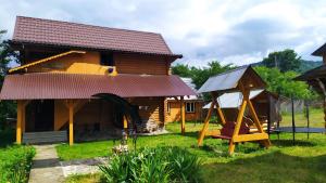 Cabaña de madera con columpio y parque infantil en Говерлянка, en Vorokhta