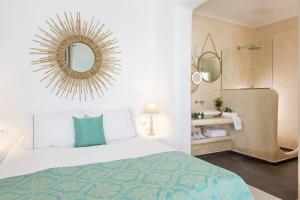 a bedroom with a bed and a mirror and a sink at Colours of Mykonos Luxury Residences & Suites in Psarou