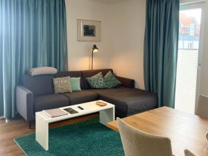 ein Wohnzimmer mit einem Sofa und einem Tisch in der Unterkunft Apartments Boardinghaus Norderney in Norderney