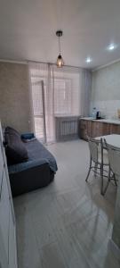 1 dormitorio con 1 cama, mesa y sillas en Однокомнатная квартира в районе ЖК Аружан, en Kokshetau