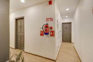 a hallway with two doors and a fire extinguisher on a wall at OYO Townhouse 591 Hotel Woodland in Nagpur