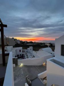 uma vista para o pôr-do-sol a partir do telhado de um edifício em Ianthe Apartments & Villa em Oia