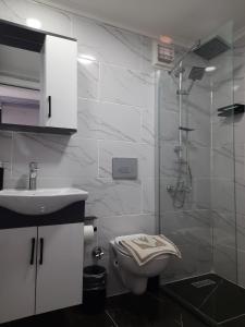 a bathroom with a shower and a toilet and a sink at Ephesian Hotel & Guesthouse in Kusadası