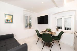 a living room with a table and chairs and a couch at Canta Amore Suites in Zadar