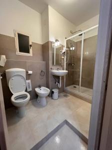 a bathroom with a toilet and a sink and a shower at Shelter Affittacamere in Genoa