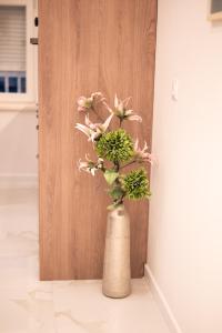 a vase with flowers in it next to a door at Canta Amore II in Zadar