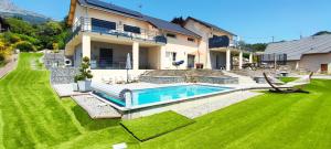 une maison avec une piscine dans une cour dans l'établissement chambre 2 vue lac av piscine, à Prunières