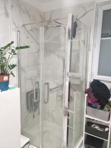 een douche met een glazen deur in een kamer bij House with outbuilding near Stade de France in Épinay-sur-Seine