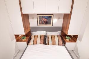 a small room with a bed and two pillows at Canta Amore Suites in Zadar
