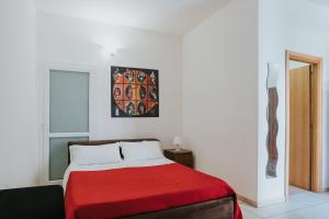 um quarto com uma cama com um cobertor vermelho em B&B Nuovo Reale - CENTRO STORICO em Lecce