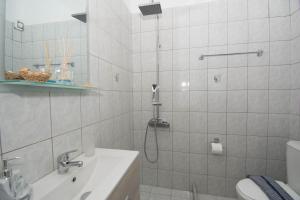a bathroom with a shower and a sink and a toilet at Jasmine Suites "By Checkin" in Sisi