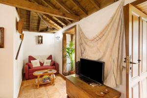 a living room with a tv and a red couch at Casa Rural Ciso in Tijarafe