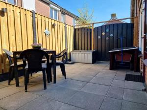 a patio with a table and chairs and a wooden fence at Sfeervolle vakantiewoning Domburg DO15 in Domburg
