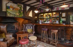a bar with leather chairs and a wooden counter at Chequers Inn by Greene King Inns in Maresfield