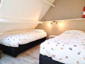 two twin beds in a room with a window at Sfeervolle vakantiewoning Domburg DO15 in Domburg