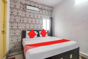 a bedroom with a bed with red pillows on it at Super OYO Oxy Rudra Inn in Rānchī