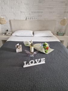 a bed with a bottle of wine and flowers on it at Ianthe Apartments & Villa in Oia