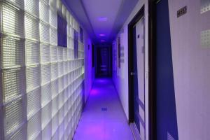 un pasillo con una luz púrpura en un pasillo en Hotel Liberty en Ahmedabad