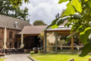 a house with a conservatory with tables and chairs at Hotel Zur Linde Dein Self Check In in Michendorf