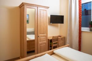 a small room with a bedroom and a mirror at Landhaus Storch - Pension in Gänserndorf