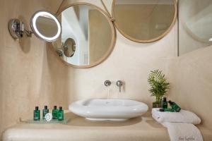 a bathroom with a sink and a mirror at Colours of Mykonos Luxury Residences & Suites in Psarou