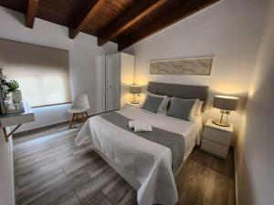 a bedroom with a large white bed and wooden floors at DON LEONE Hotel in Alginet