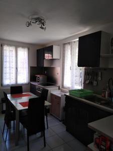 a kitchen with a table and chairs and a table and a kitchen with a kitchen at Appart du 21 in Sainte-Marie-aux-Mines