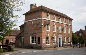 an old red brick building on a street at Chequers Inn by Greene King Inns in Maresfield