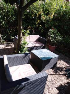 a patio with two wicker chairs and a table at Appart du 21 in Sainte-Marie-aux-Mines