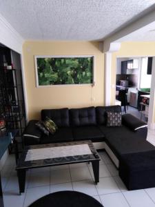 a living room with a black couch and a table at Appart du 21 in Sainte-Marie-aux-Mines +1 photo