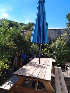 a blue umbrella sitting on top of a wooden table at Appart du 21 in Sainte-Marie-aux-Mines