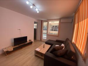 a living room with a couch and a tv at Apartamenti Ely in Pomorie