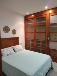 a bedroom with a bed and a wooden cabinet at Arco Centro Cádiz in Cádiz